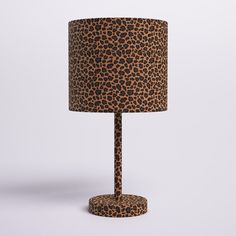 a leopard print lamp shade on a white background with a black and brown floor mat