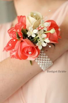 a bridesmaid's wrist corsage with flowers and pearls