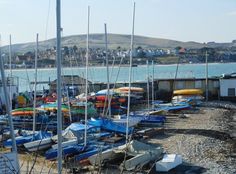 many boats are parked on the shore by the water