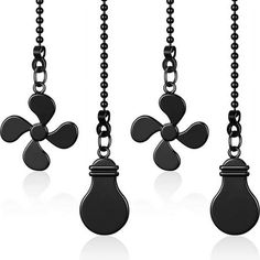 four black objects hanging from chains on a white background