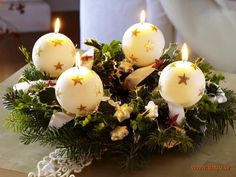 a bunch of lit candles sitting on top of a box with greenery around it