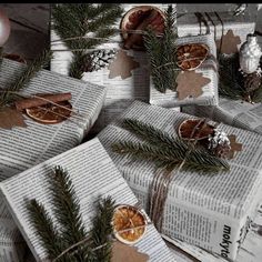 christmas presents wrapped in newspaper and decorated with orange slices, pine cones and cinnamons