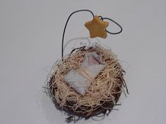 an ornament with a bird's nest and star hanging from the top