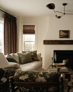 a living room filled with furniture and a fire place in front of a large window