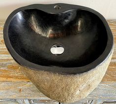 a black sink sitting on top of a wooden table