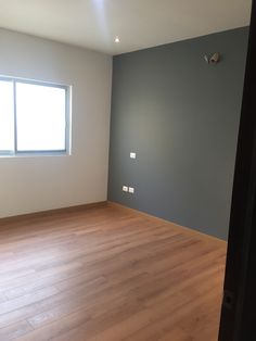 an empty room with hard wood floors and no one is in the house or someone has just bought it