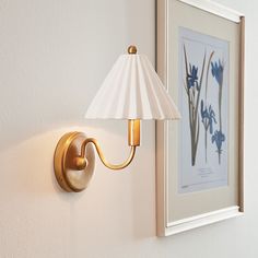 a lamp is mounted on the wall next to a painting