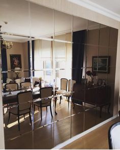 the reflection of a dining room table and chairs in a mirrored doored wall mirror