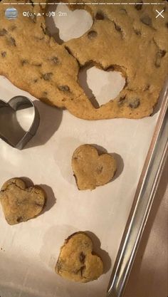 chocolate chip cookies in the shape of heart shaped cookie cutters on a baking sheet