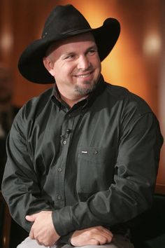 a man wearing a cowboy hat sitting in a chair