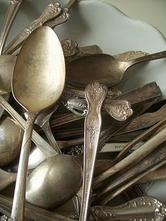 an assortment of spoons and forks in a bowl