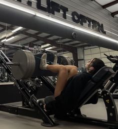 a man laying on top of a bench in a gym next to an exercise machine