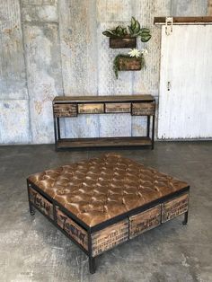 a brown leather ottoman sitting on top of a cement floor next to a wooden table