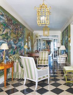 a living room filled with furniture and a painting on the wall next to a chandelier