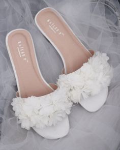 the bride's shoes are adorned with white flowers and tulle skirted fabric