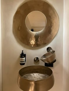 a bathroom with a sink, mirror and soap dispenser on the wall