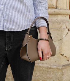 Prestigious and modern, our taupe Mini Pivoine handbag embodies timelessness with elegance.
Handcrafted in our Italian workshop, this bag is designed from the highest quality grained calf leather, adorned with meticulous golden finishes. Versatile, it can be carried by hand, on the shoulder, or crossbody thanks to its additional strap. Its solid zipper reveals a beige interior, ensuring a safe and organized space for your essentials. Luxury Taupe Leather Shoulder Bag, Timeless Beige Textured Leather Shoulder Bag, Timeless Beige Bag With Smooth Grain, Luxury Soft Leather Bag In Taupe, Taupe Textured Leather Shoulder Bag For Office, Luxury Taupe Soft Leather Bag, Luxury Taupe Textured Leather Bag, Elegant Beige Shoulder Bag With Smooth Grain, Formal Beige Satchel With Smooth Grain