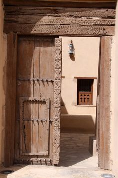 an old wooden door is open in front of a building