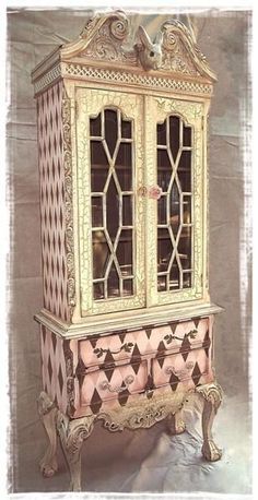 an antique china cabinet painted in pink and gold