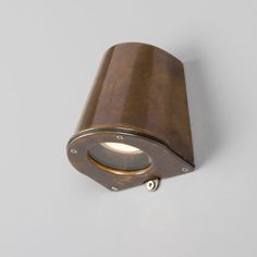 a close up of a wall light on a white surface with a grey back ground