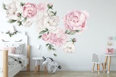 a child's bedroom with pink flowers on the wall