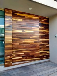 a large wooden wall on the side of a building next to a door with glass windows