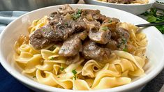 a white bowl filled with pasta and meat