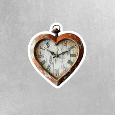 a heart shaped clock hanging from the side of a wall