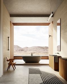 a bathroom with a large bathtub sitting next to a wooden table and chair in front of a window