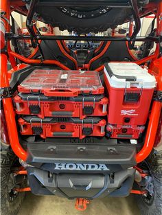 the back end of an orange honda four wheeler with two red boxes on it's trunk