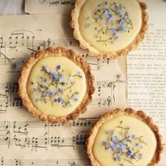 three pies with flowers on top of sheet music