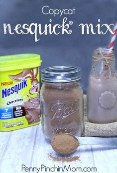 two mason jars filled with ice cream next to a canister of chocolate milk and a spoon