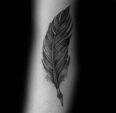 a black and white photo of a feather tattoo