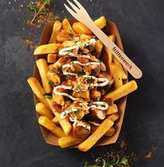 french fries topped with meat and sauce on a plate next to a knife and fork