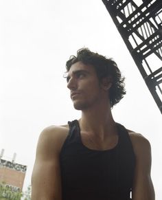 a man standing in front of a metal structure with his hands on his hips and looking off into the distance