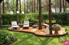 a wooden deck in the middle of a lush green yard with white chairs and trees