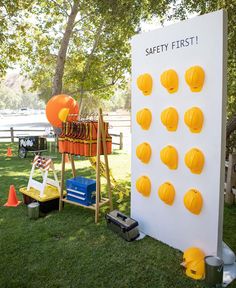 there is a safety first sign in the grass next to an orange and white board