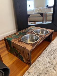 a dog bowl on top of a wooden table in front of a mirror