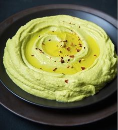 a black plate topped with an avocado hummus