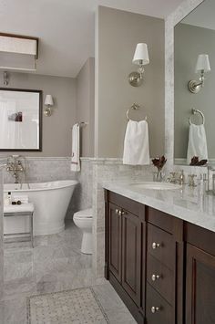 a bathroom with two sinks, a toilet and a bathtub in it's center