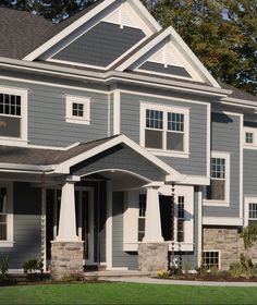 two story house with gray siding and white trim on the front, green grass in front