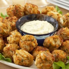 a white plate topped with meatballs covered in ranch dressing and garnished with lettuce