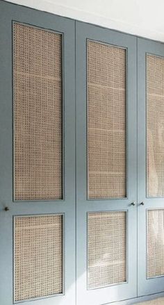 an empty room with blue doors and wicker panels