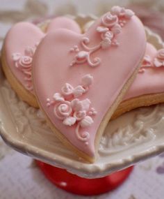 two heart shaped cookies sitting on top of a plate