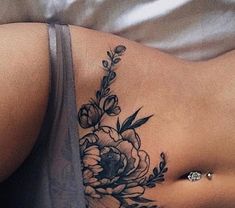 a woman's stomach with a flower tattoo on her left side and the bottom part of her stomach