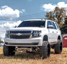 a white truck parked on top of a dry grass field