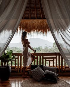 a woman in a white dress standing on a balcony