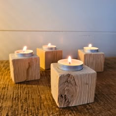 three tea lights sitting on top of wooden blocks