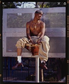 a shirtless man sitting on top of a fire hydrant