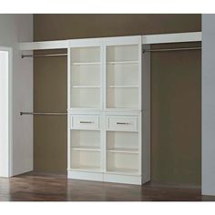 an empty closet with white shelves and drawers